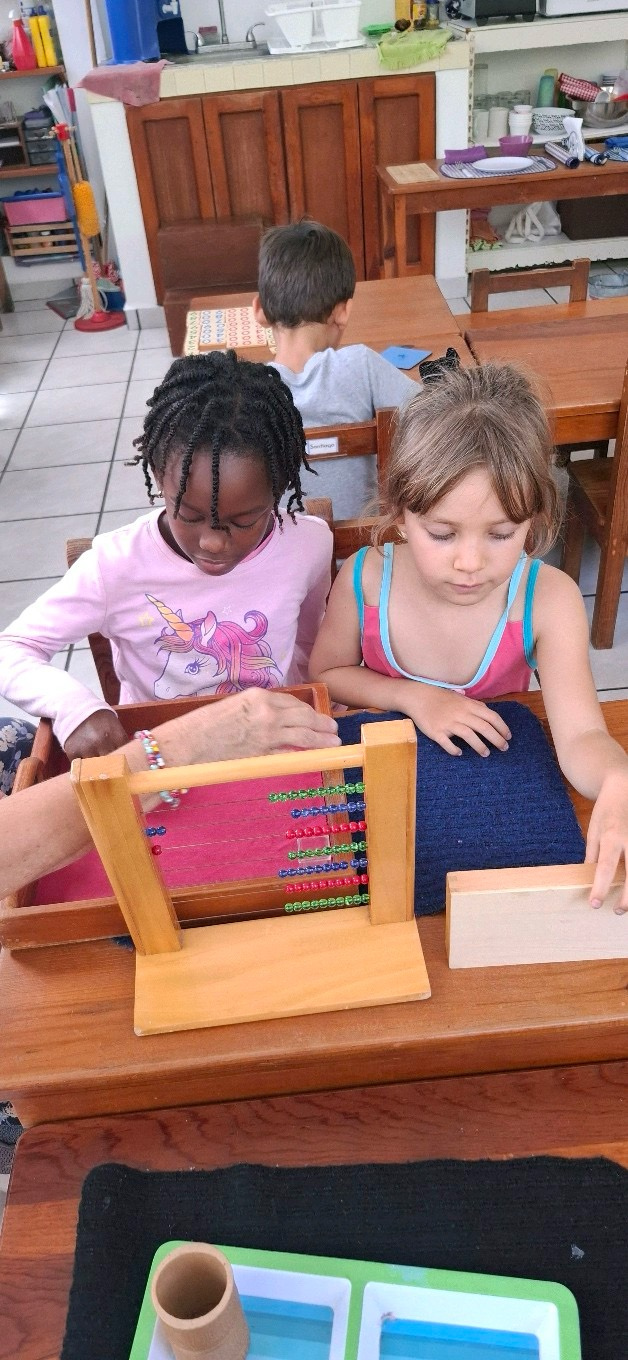 Dos niñas trabajando juntas con material de matemáticas