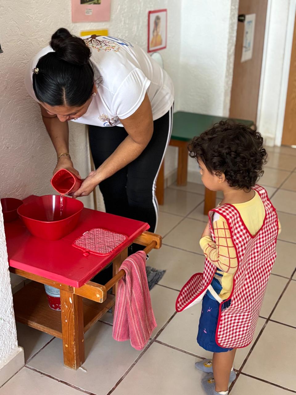 Guía de GAL acompañando a un niño durante una actividad de vida práctica